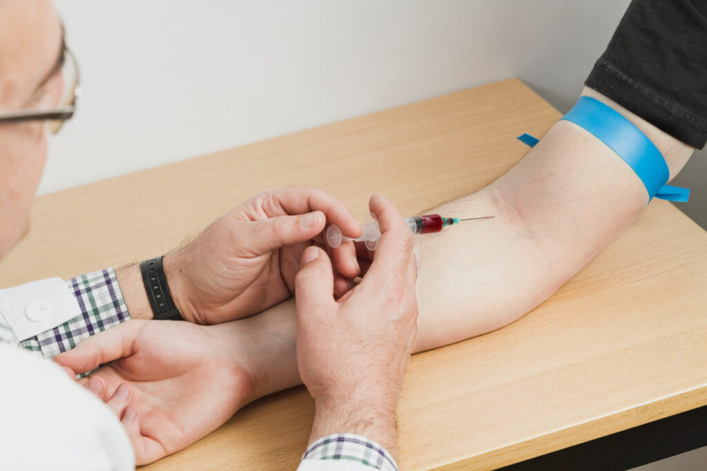 medtech getting blood sample from a patient at a diabetes testing faclity