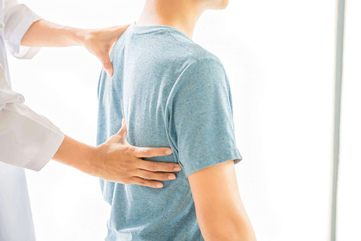 doctor checking patient wiith scoliosis