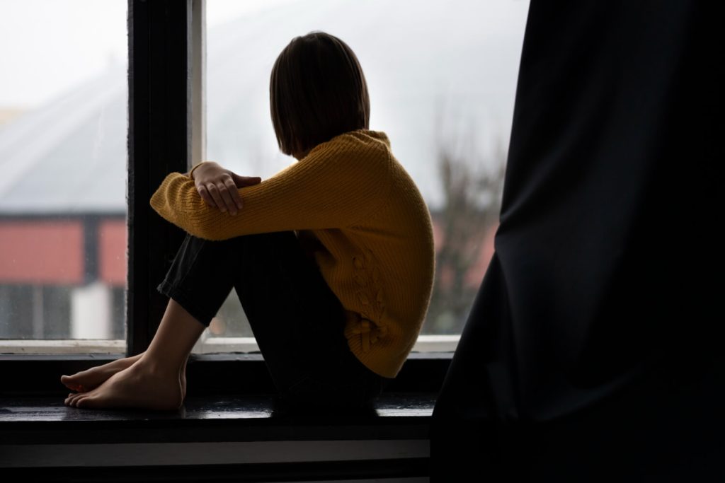 woman sitting on the ledge of the window - passive suicide ideation