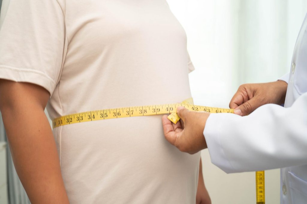 patient getting measured in th waist by a weight management doctor